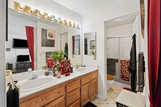 a bathroom with a double vanity sink mirror and toilet