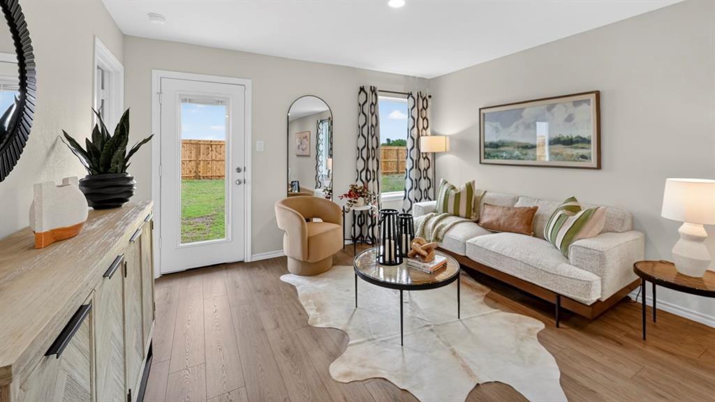 3514 Spring Time Street Terrell, TX 75126 - Photo 11 of 26 Spacious living area featuring wood-finish flooring, light-toned walls, and a glass-paneled exterior door