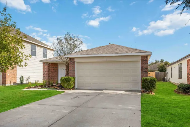 a view of a house with a yard and large tree