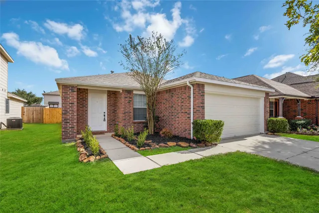 a front view of a house with a garden and yard