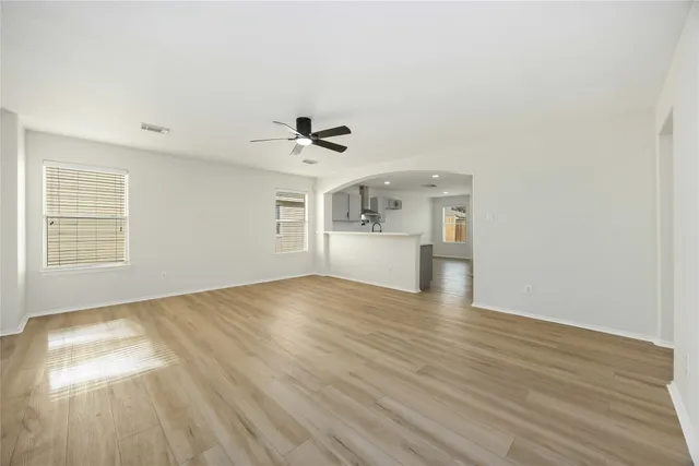 a view of empty room with wooden floor and windows