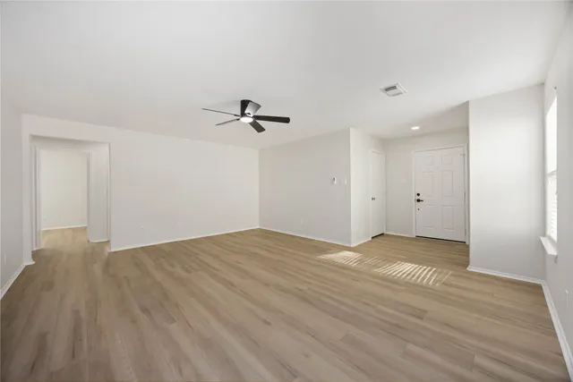 a view of empty room with wooden floor