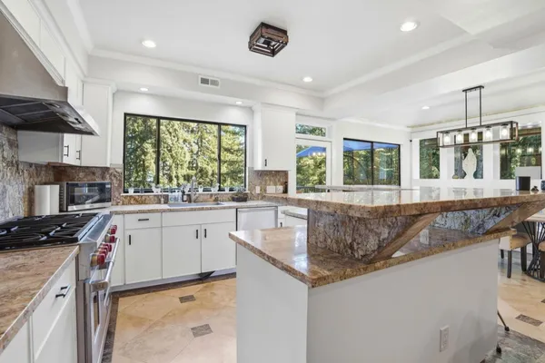 a kitchen with granite countertop a sink window and cabinets