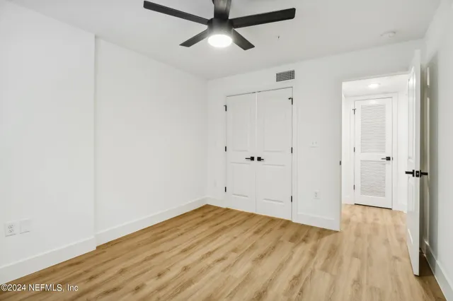 a view of empty room with wooden floor