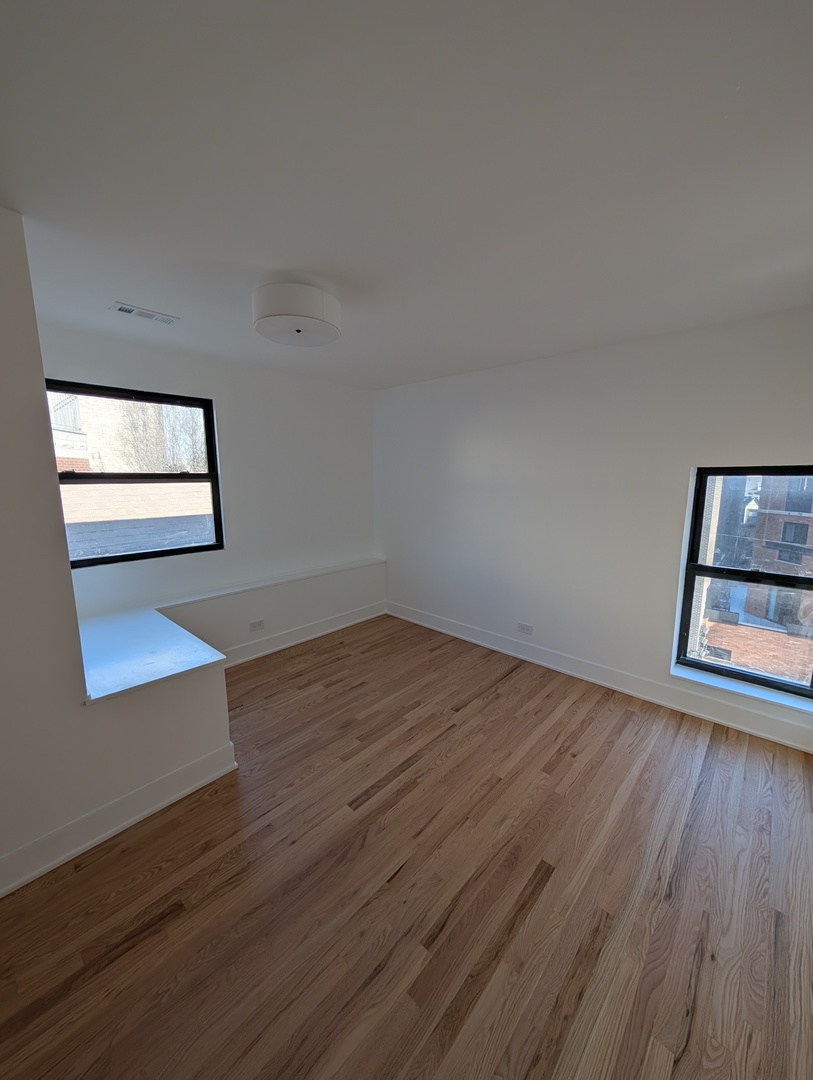 916 North Noble Street, Unit 2F Chicago, IL 60642 - Photo 15 of 22 a view of empty room with wooden floor and fan