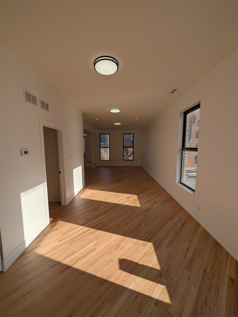 916 North Noble Street, Unit 2F Chicago, IL 60642 - Photo 18 of 22 a view of a livingroom with wooden floor and a ceiling fan