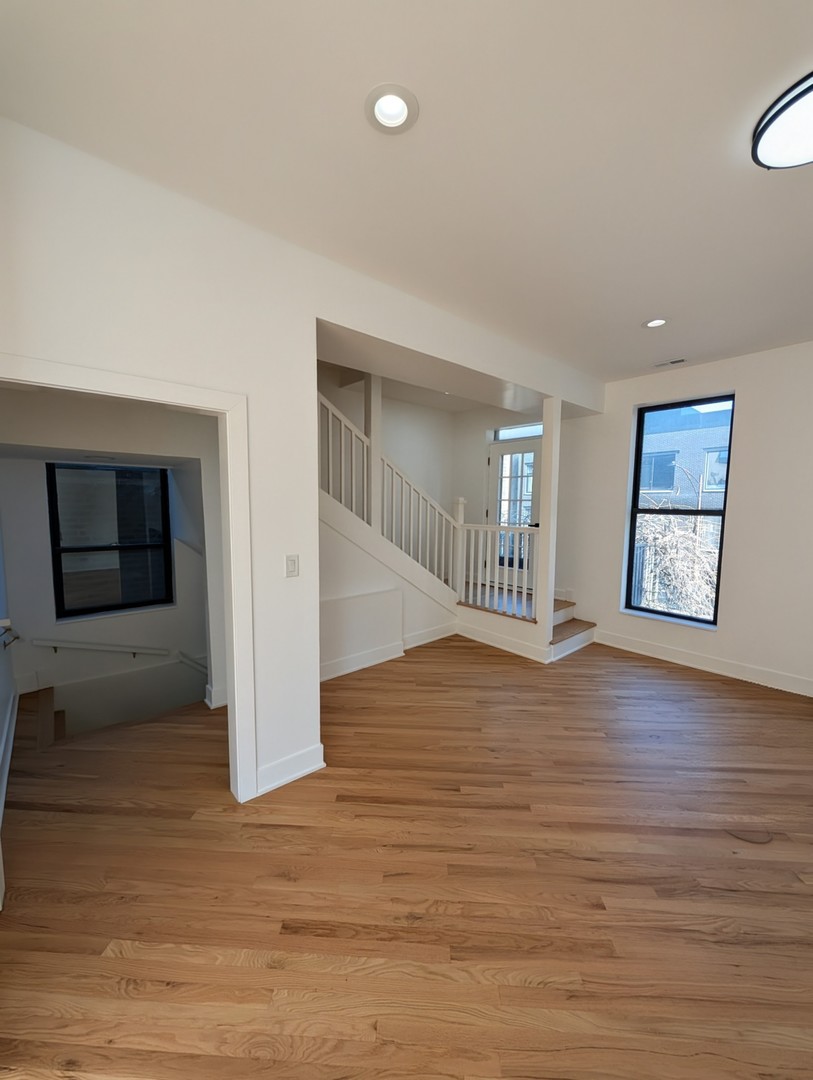 916 North Noble Street, Unit 2F Chicago, IL 60642 - Photo 4 of 22 a view of an empty room with window and wooden floor