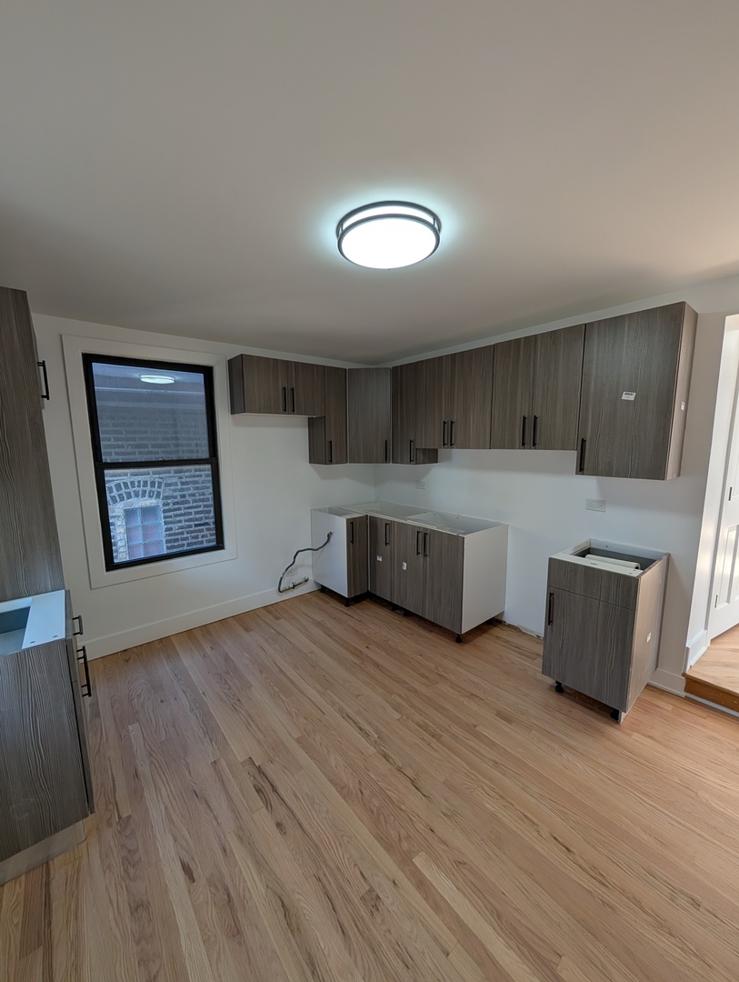 916 North Noble Street, Unit 2F Chicago, IL 60642 - Photo 7 of 22 a large kitchen with wooden floor and stainless steel appliances