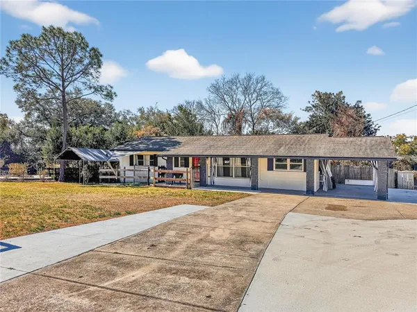 a front view of a house with a yard and swimming pool