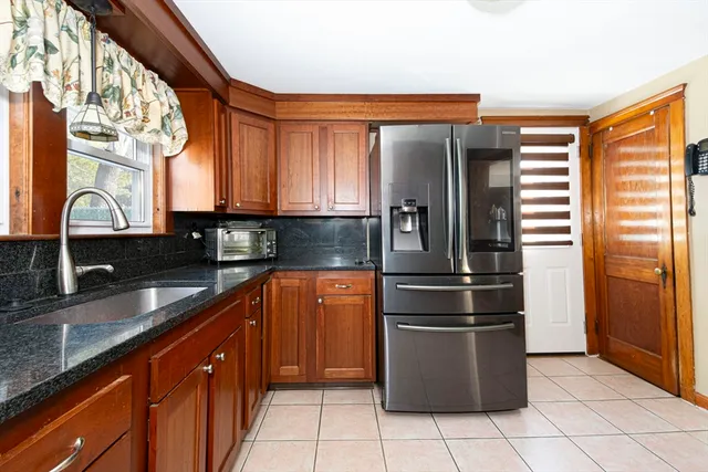 a kitchen with stainless steel appliances granite countertop a refrigerator and a sink
