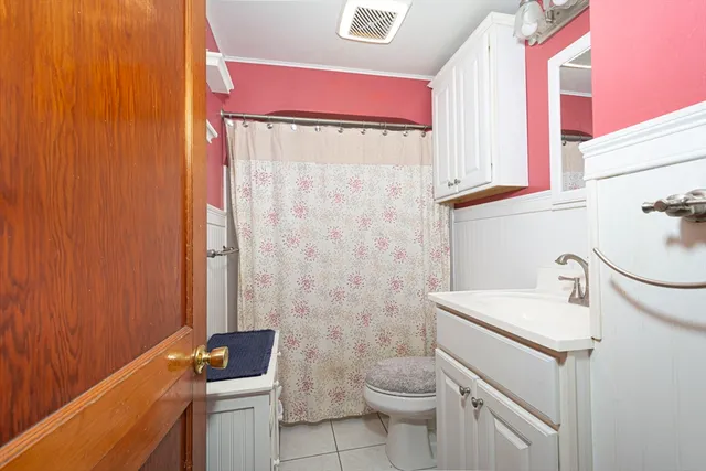 a bathroom with a sink a toilet and shower curtain