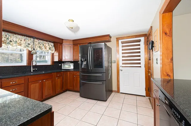 a kitchen with stainless steel appliances granite countertop a refrigerator and a sink