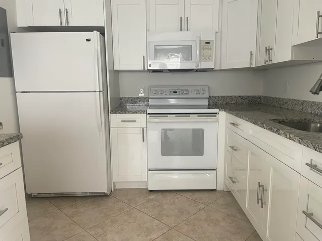 a kitchen with cabinets and white appliances