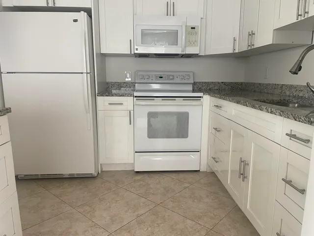 a utility room with cabinets washer and dryer
