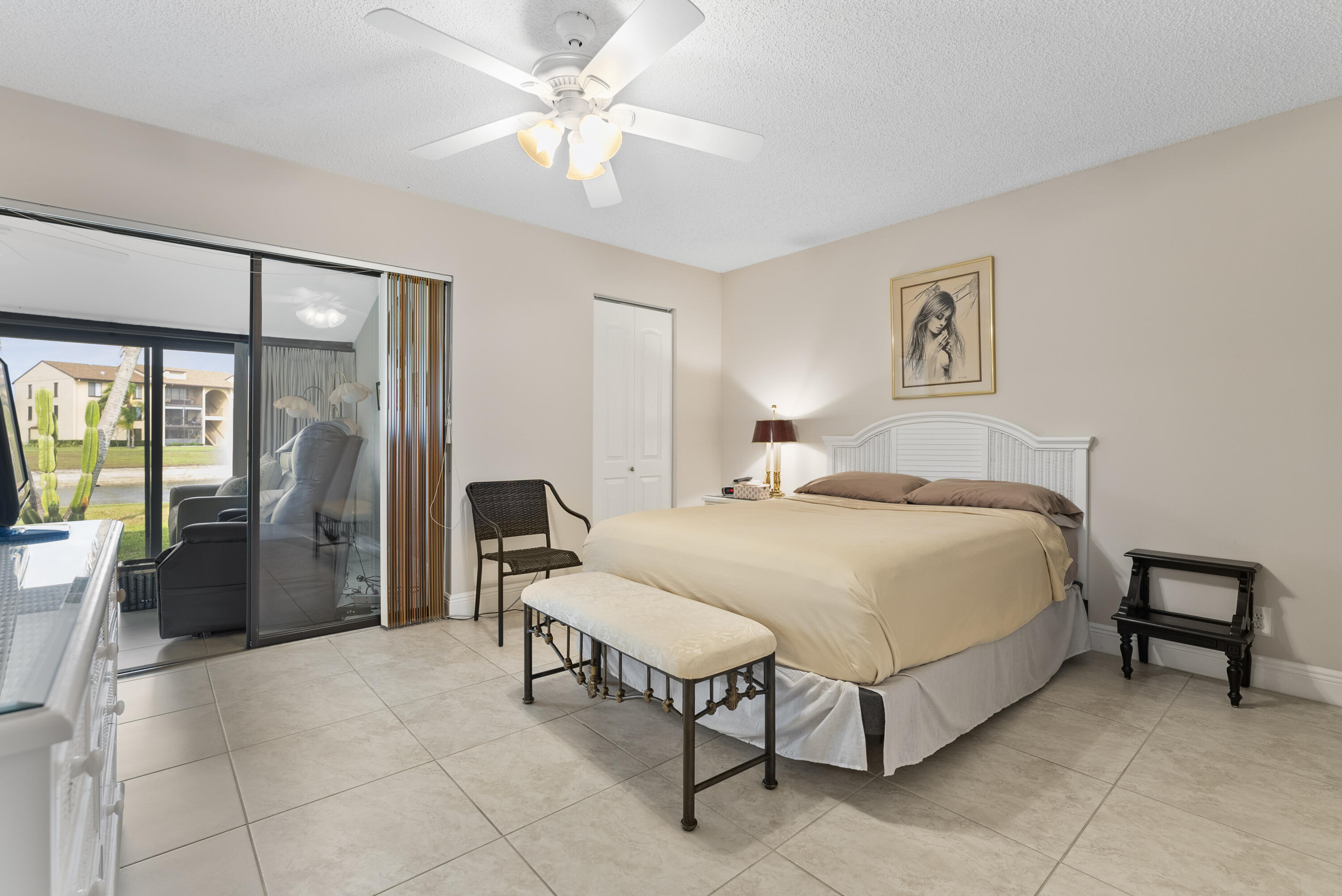 823 Sky Pine Way, Unit D Greenacres, FL 33415 - Photo 20 of 34 a spacious bedroom with a bed and a chandelier