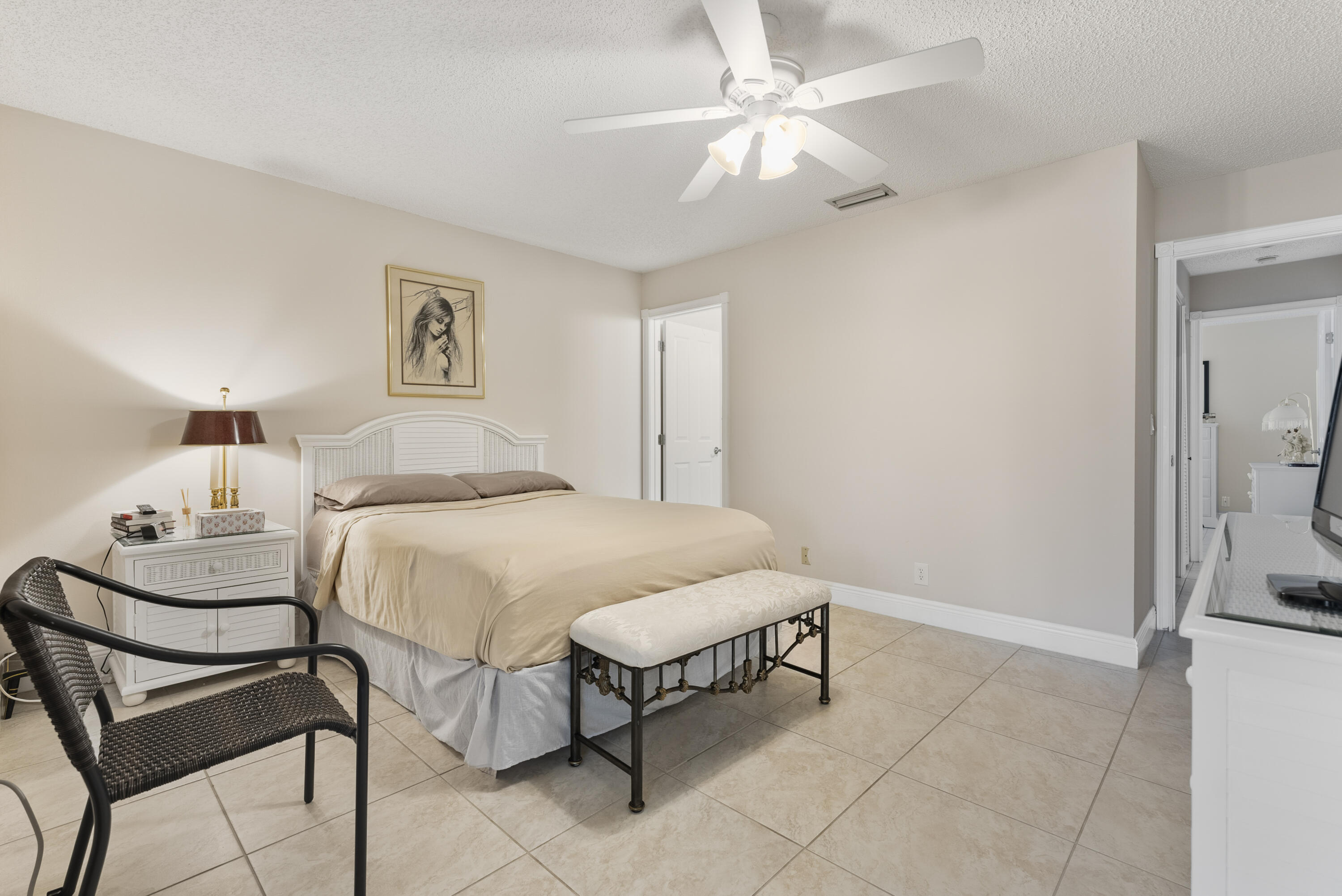 823 Sky Pine Way, Unit D Greenacres, FL 33415 - Photo 21 of 34 a bedroom with a bed and a chandelier