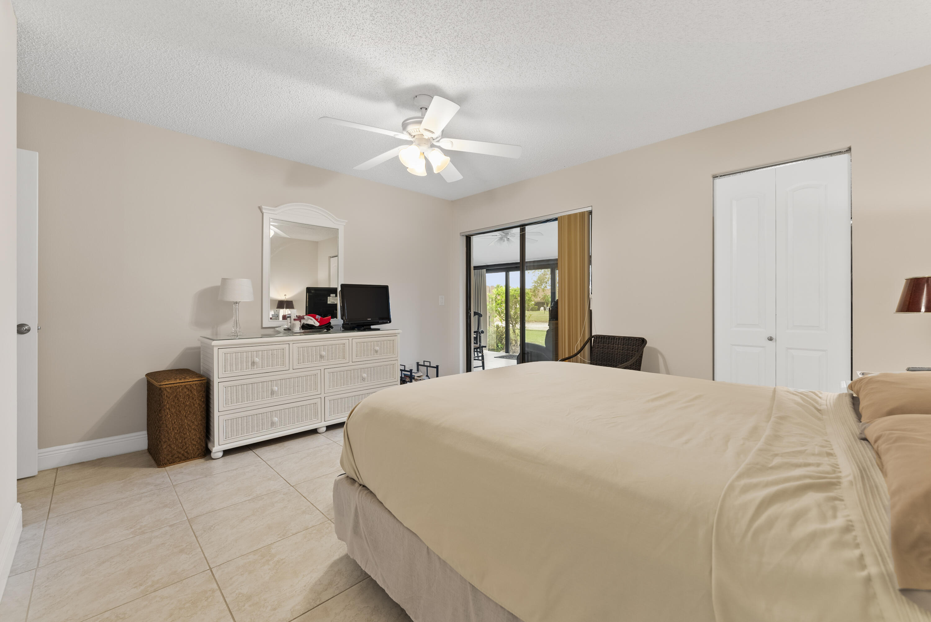 823 Sky Pine Way, Unit D Greenacres, FL 33415 - Photo 22 of 34 a bedroom with a large bed and a chandelier