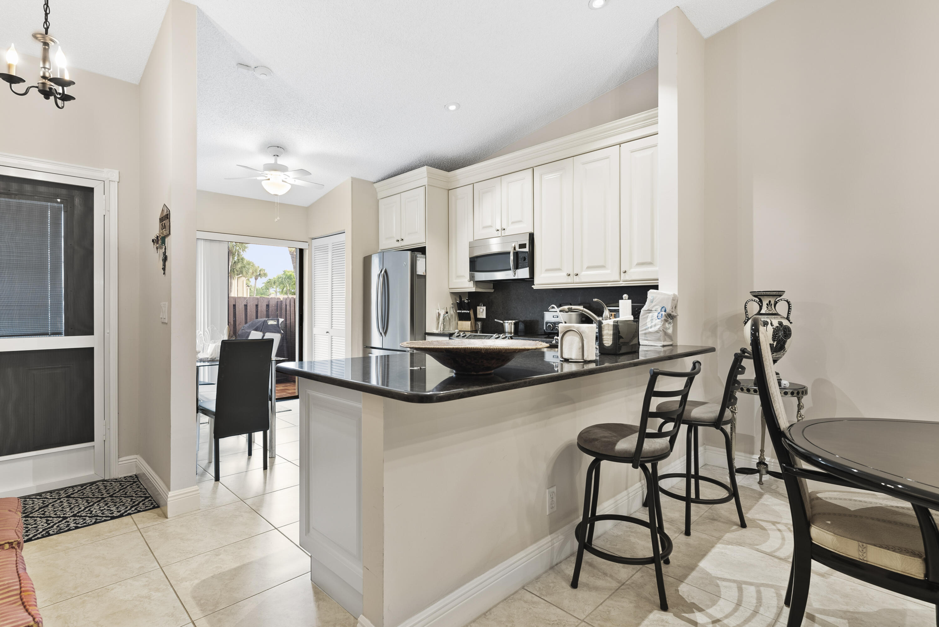 823 Sky Pine Way, Unit D Greenacres, FL 33415 - Photo 9 of 34 a kitchen with stainless steel appliances kitchen island granite countertop a refrigerator and cabinets