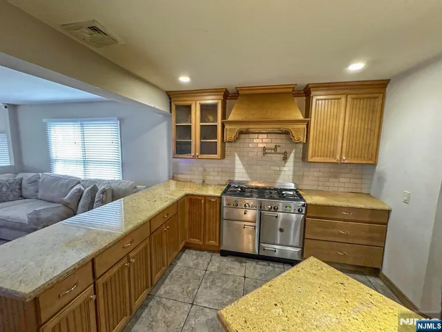 a kitchen with stainless steel appliances granite countertop a stove and a sink