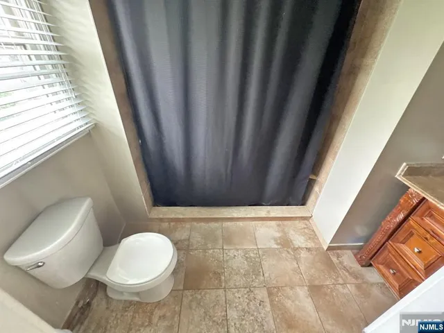a bathroom with a toilet and a shower curtain