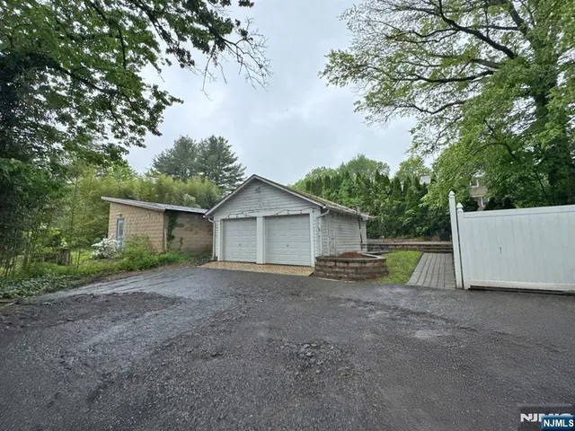 a view of a house with a yard and large tree