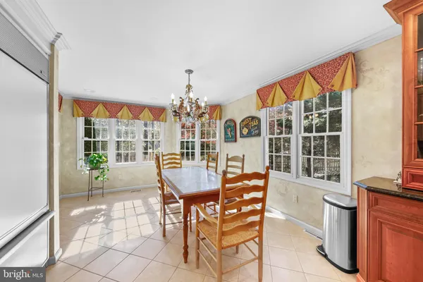 a dining room with furniture a chandelier and wooden floor