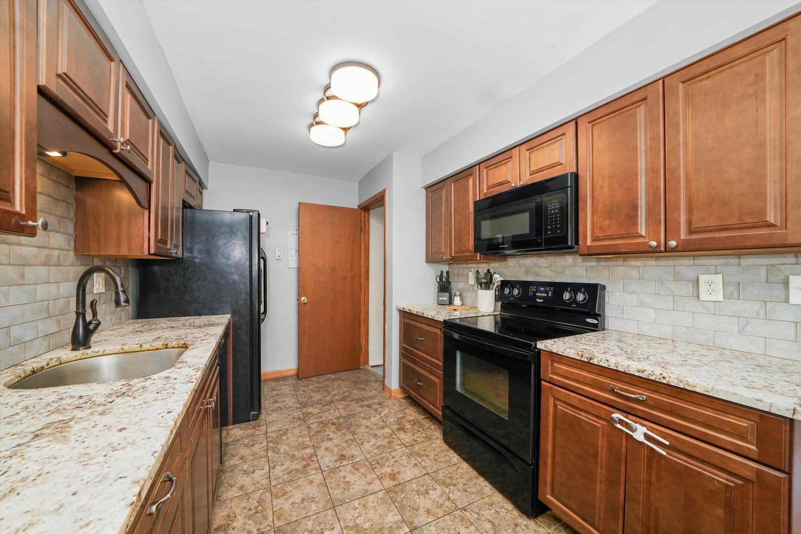 316 Circlegate Road New Lenox, IL 60451 - Photo 10 of 24 a kitchen with stainless steel appliances granite countertop a sink stove microwave and refrigerator