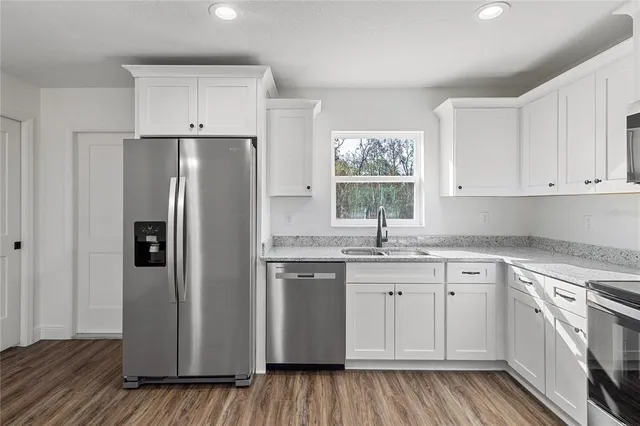 a kitchen with stainless steel appliances granite countertop a refrigerator sink and cabinets