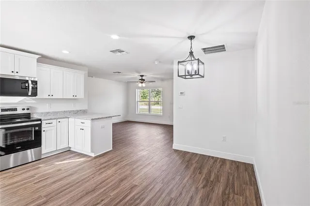 a view of kitchen view wooden floors appliances and cabinets