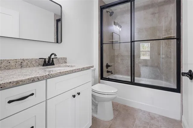 an empty room with wooden floor closet and windows