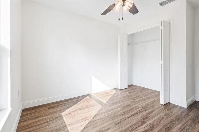 a view of empty room with wooden floor
