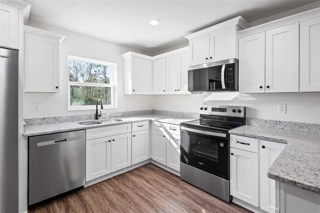 a kitchen with stainless steel appliances granite countertop a refrigerator sink and cabinets