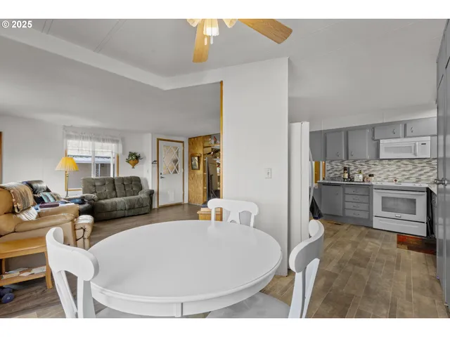 a living room with stainless steel appliances furniture and a kitchen view