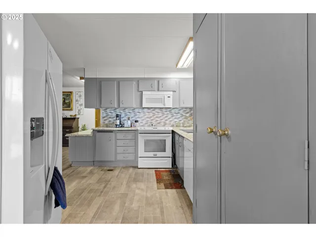 a kitchen with a refrigerator and white cabinets