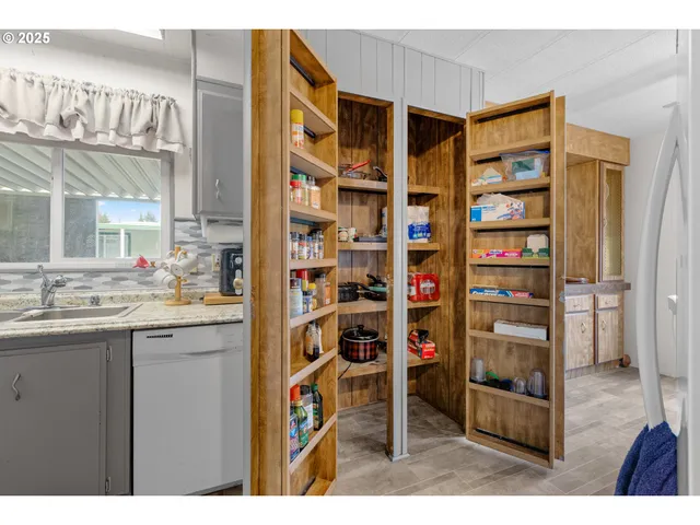 a kitchen with stainless steel appliances cabinets and a large window