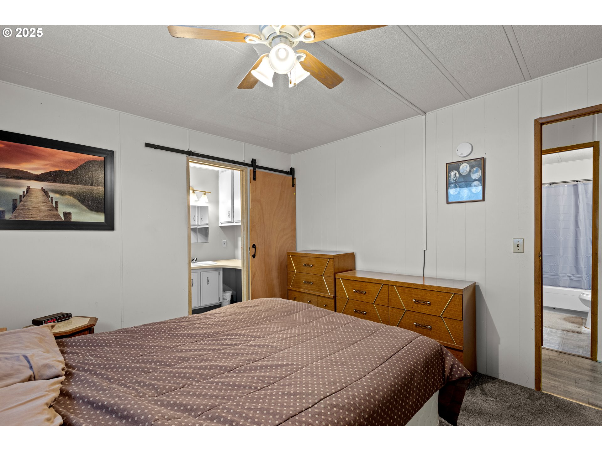 125 Estate Loop Winston, OR 97496 - Photo 22 of 45 a bedroom with a bed and a chandelier