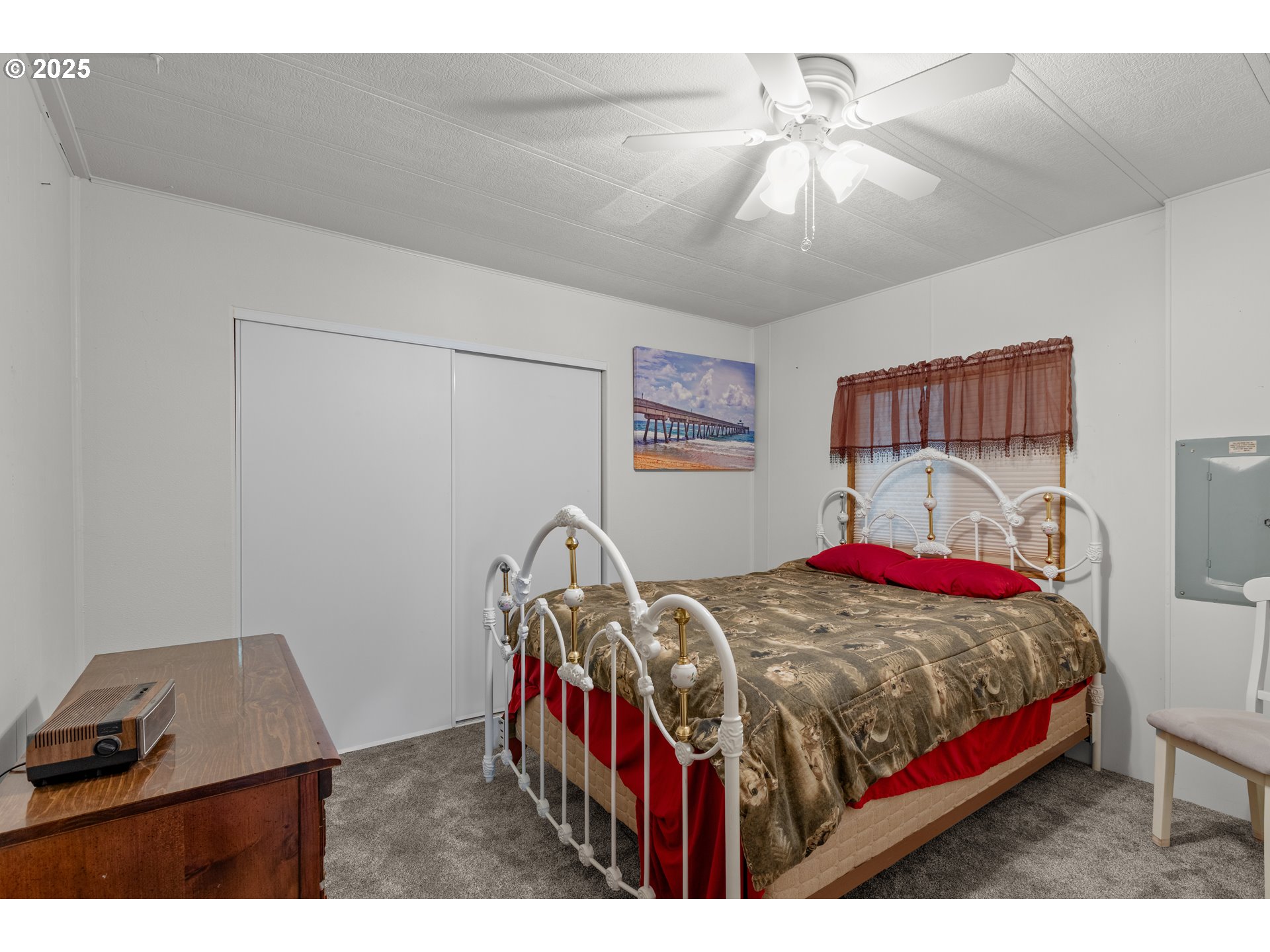125 Estate Loop Winston, OR 97496 - Photo 25 of 45 a bedroom with a bed a chandelier and a desk