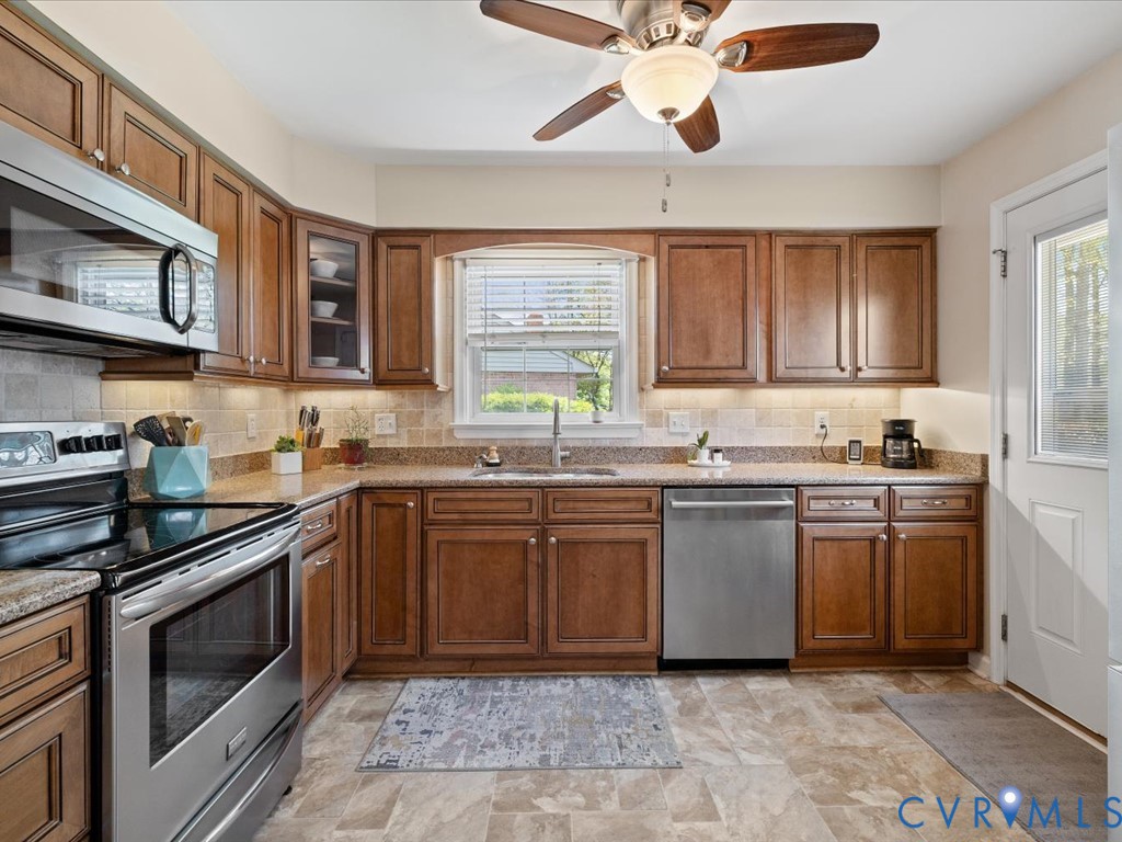 1455 Robindale Road Richmond, VA 23235 - Photo 9 of 29 a kitchen with stainless steel appliances granite countertop a stove sink and cabinets