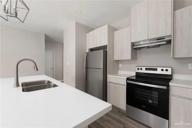 a kitchen with stainless steel appliances a stove refrigerator and sink
