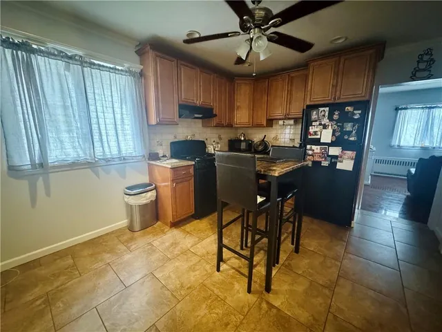 a kitchen with stainless steel appliances granite countertop a sink a stove a refrigerator cabinets and dining table