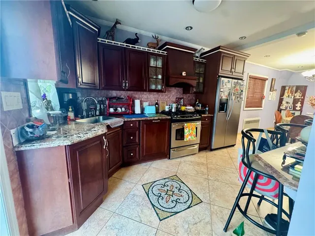 a kitchen with stainless steel appliances granite countertop a sink stove and refrigerator