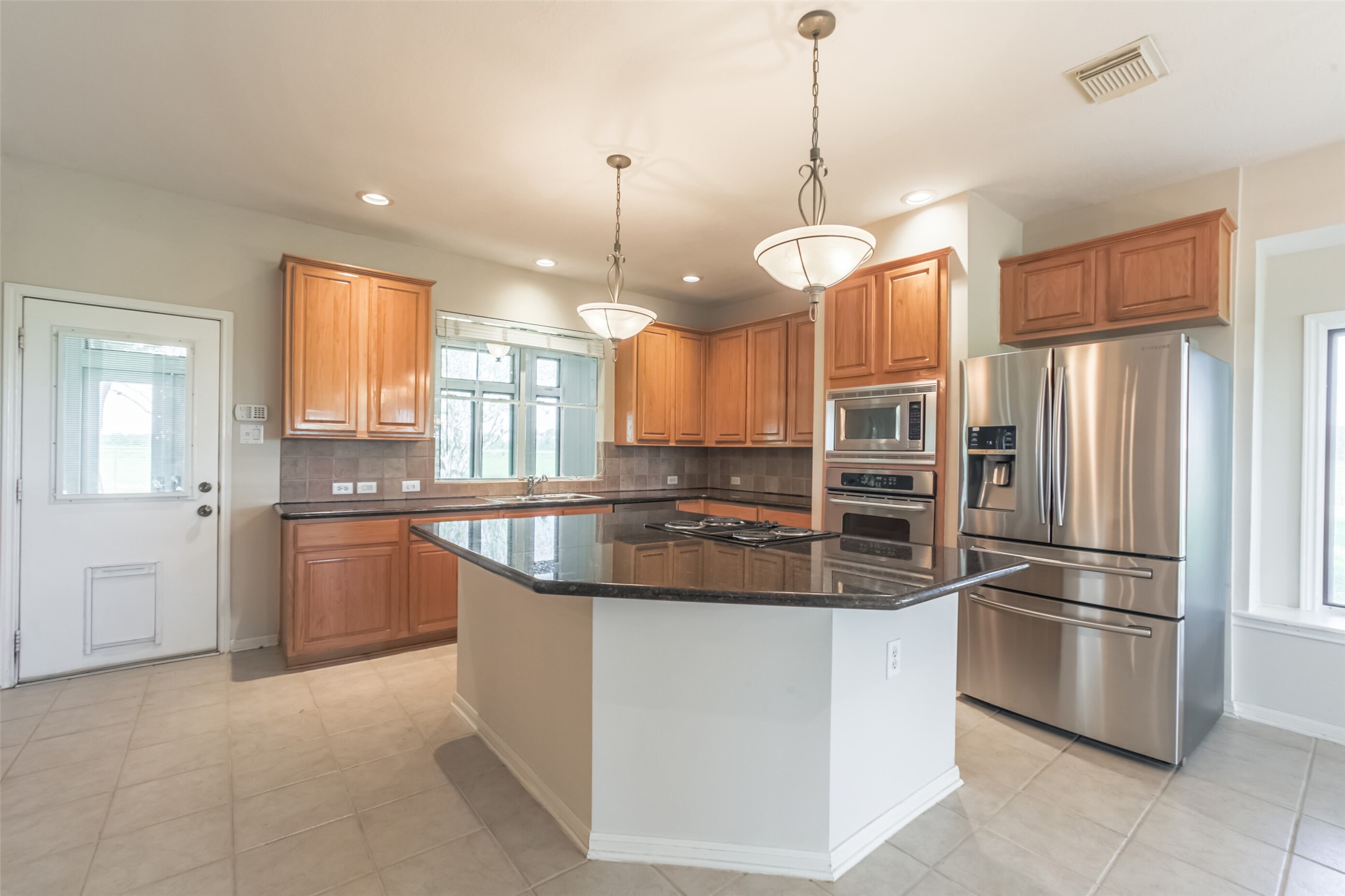 4903 Bowser Road Fulshear, TX 77441 - Photo 16 of 50 a kitchen with stainless steel appliances granite countertop a refrigerator a stove a sink and a refrigerator