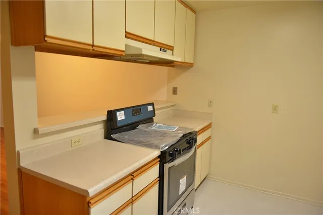 a kitchen with stainless steel appliances cabinets and wooden floor