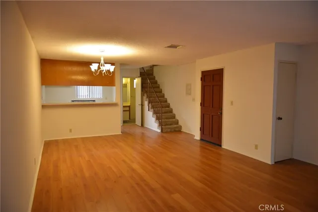 a view of a room with wooden floor and a kitchen