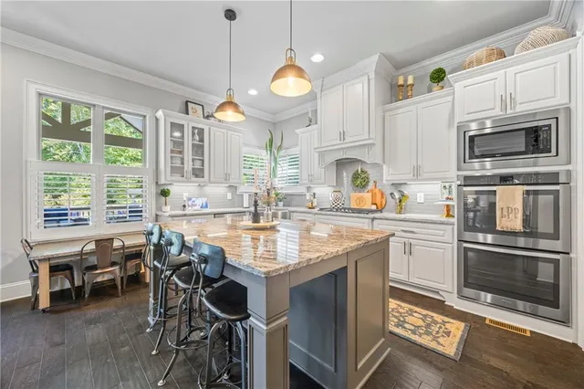 a kitchen with granite countertop a stove a sink and a refrigerator