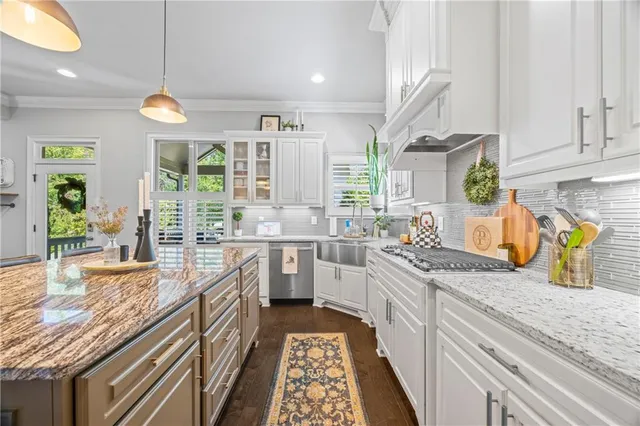 a large kitchen with granite countertop a lot of counter space and a wooden floor