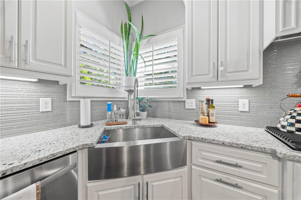 3111 Old Thompson Mill Road Buford, GA 30519 - Photo 18 of 52 a kitchen with granite countertop a sink white cabinets and a window