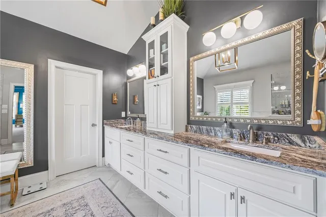 a spacious bathroom with a tub a sink and a large mirror