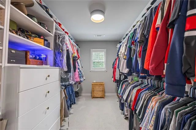 a view of walk in closet with clothes