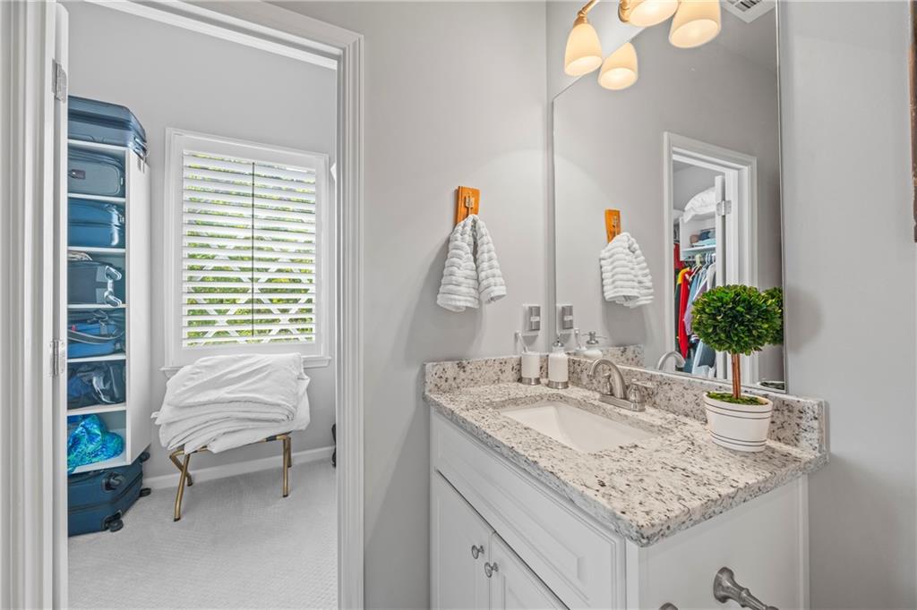 3111 Old Thompson Mill Road Buford, GA 30519 - Photo 37 of 52 a en suite bathroom with a granite countertop sink and a mirror